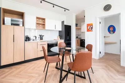 a kitchen and dining room with a glass table and chairs at Century City Natures Treat in Cape Town