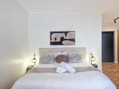 a bedroom with a large white bed with two pillows at On Park - Century City Lux Studio Apartment in Cape Town