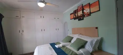 a bedroom with a bed with white cabinets and a ceiling fan at Ojong's Self-Catering Ridgeworth - Bellville in Tyger Valley