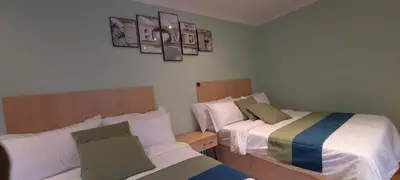 two beds in a small room with two bedsskirts at Ojong's Self-Catering Ridgeworth - Bellville in Tyger Valley