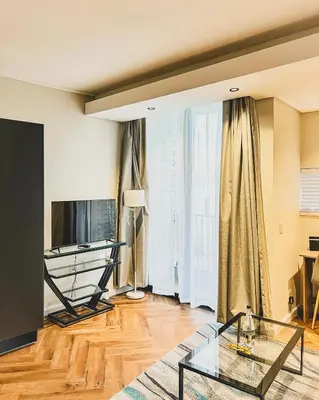 a living room with a television and a glass table at Luxe Studio - On Park near Canal walk Century City in Cape Town