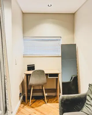 a room with a desk and a chair and a window at Luxe Studio - On Park near Canal walk Century City in Cape Town