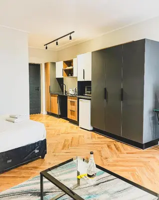 a living room with a bed and a kitchen at Luxe Studio - On Park near Canal walk Century City in Cape Town