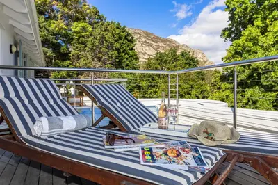 a pair of deck chairs sitting on a porch at Escape to Hermanus Spacious Family Home in Hermanus