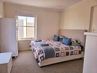 a bedroom with a bed and a window at Escape to Hermanus Spacious Family Home in Hermanus