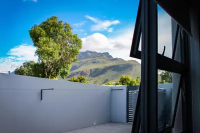 a view of the mountains from a house window at Upmarket Room in Stellenbosch