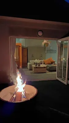 a living room with a fire pit in the middle of a room at Beach Pebble - 200m walk to beach kite surfer paradise, work friendly, pet friendly - must request in Bloubergstrand