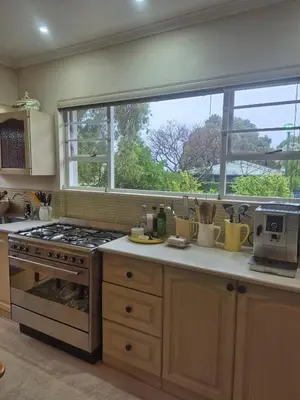 a kitchen with a stove and a large window at Serendipity 2 Bedroom Family Home in Onrus in Hermanus