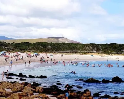 a large group of people on a beach at Serendipity 2 Bedroom Family Home in Onrus in Hermanus