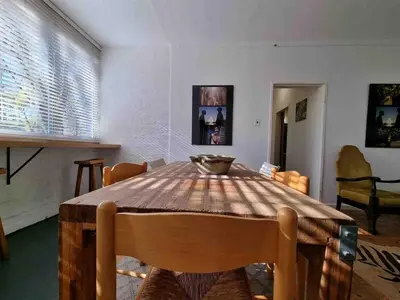 a dining room with a wooden table and chairs at Sunny Spacious Stellenbosch 3 bed garden apartment in Stellenbosch