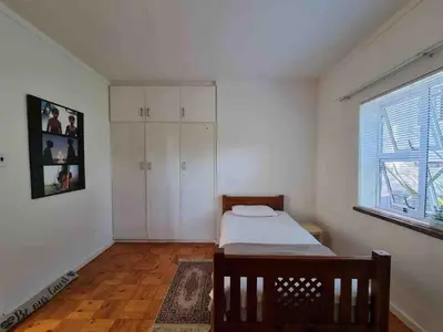 a bedroom with a bed and a large window at Sunny Spacious Stellenbosch 3 bed garden apartment in Stellenbosch