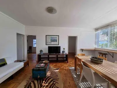 a living room with a couch and a table at Sunny Spacious Stellenbosch 3 bed garden apartment in Stellenbosch