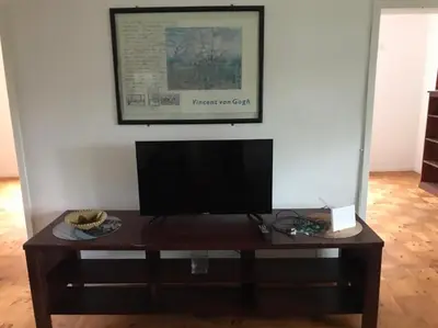 a television on a wooden table in a room at Sunny Spacious Stellenbosch 3 bed garden apartment in Stellenbosch