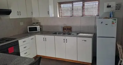a kitchen with a white refrigerator and a sink at Sir Garnet Inn in Wolseley