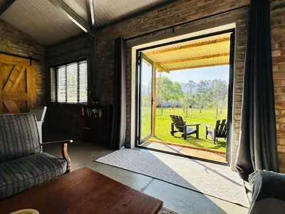 a living room with a large sliding glass door at Apple Cottage in Grabouw