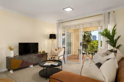 a living room with a couch and a tv at Elegant Apartment with Pool and Balcony Views in Cape Town
