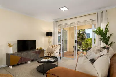 a living room with a couch and a tv at Elegant Apartment with Pool and Balcony Views in Cape Town
