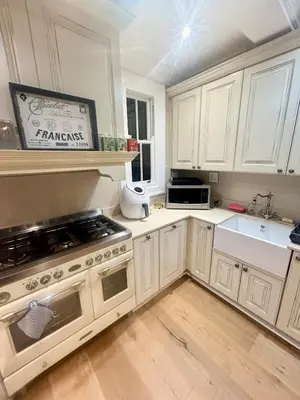 a kitchen with white cabinets and a stove top oven at French Manor 1 in Stellenbosch