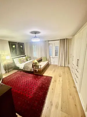 a living room with a couch and a red rug at French Manor 1 in Stellenbosch