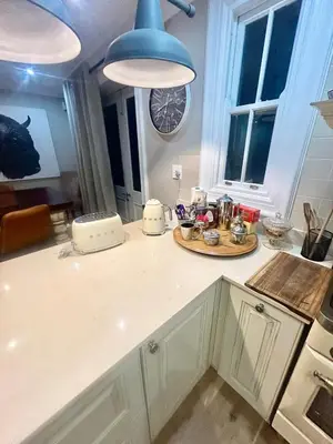 a kitchen with a counter top with a blue light fixture at French Manor 1 in Stellenbosch