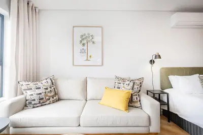 a living room with a couch and a bed at Paarl Studio 138 - Ultra Modern Apartment with AC and onsite Parking in Paarl
