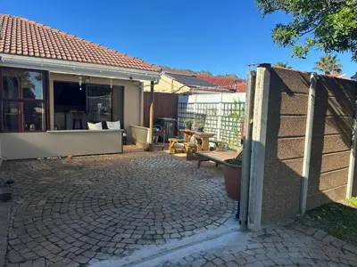 a patio of a house with a fence at Winelands Beach Cottage in Gordonʼs Bay