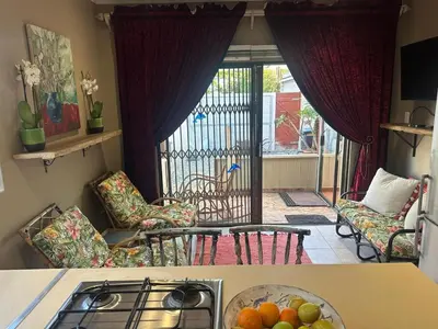 a kitchen with a stove and a bowl of fruit on a counter at Winelands Beach Cottage in Gordonʼs Bay