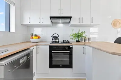 a kitchen with white cabinets and a stove top oven at Ocean View B503 in Cape Town
