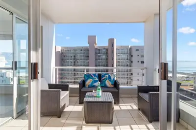 a balcony with furniture and a view of the ocean at Ocean View B503 in Cape Town