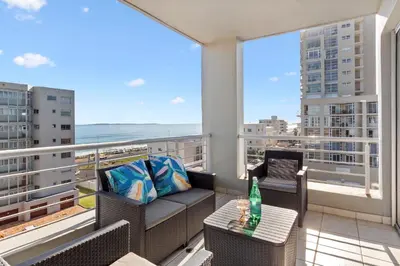 a balcony with a table and chairs and a view of the ocean at Ocean View B503 in Cape Town