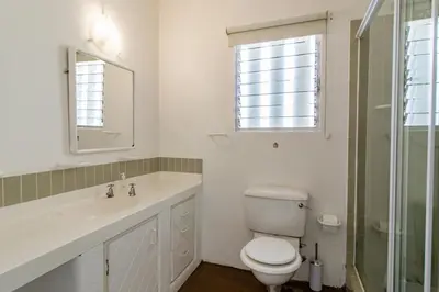 a bathroom with a toilet and a sink and a mirror at Turtle Drum ON THE BEACH in Bettyʼs Bay