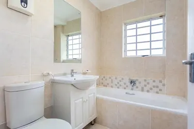 a bathroom with a toilet and a sink and a tub at Century on Lake A45 by CTHA in Cape Town