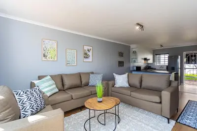 a living room with a couch and a table at Century on Lake A45 by CTHA in Cape Town