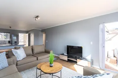 a living room with a couch and a tv at Century on Lake A45 by CTHA in Cape Town