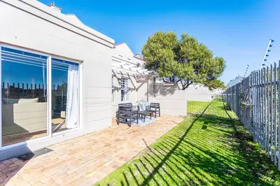 a house with a patio and a fence at Century on Lake A45 by CTHA in Cape Town