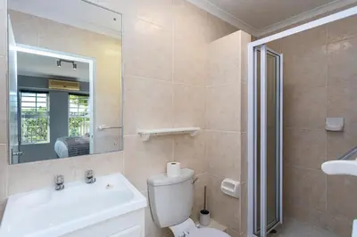 a bathroom with a toilet and a sink and a mirror at Century on Lake A45 by CTHA in Cape Town