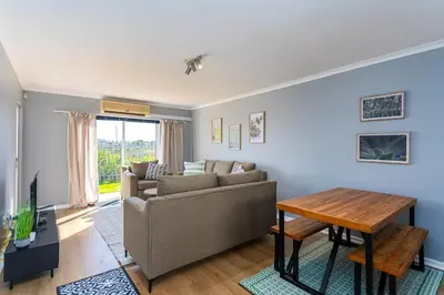 a living room with a couch and a table at Century on Lake A45 by CTHA in Cape Town