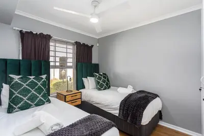 a bedroom with two beds and a window at Century on Lake A45 by CTHA in Cape Town