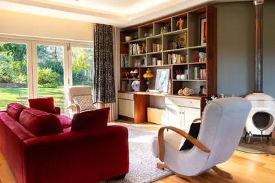 a living room with a red couch and chairs at Stellenbosch Farm Stay with Mountain Views & Pool in Stellenbosch