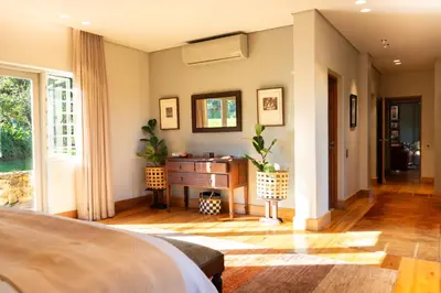 a bedroom with a bed and a desk and a window at Stellenbosch Farm Stay with Mountain Views & Pool in Stellenbosch