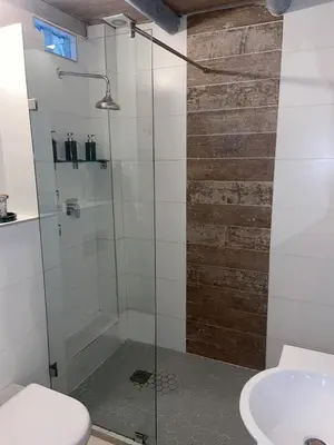 a shower with a glass door next to a sink at Amatoni 44 in Stellenbosch