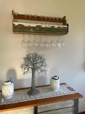a table with wine glasses and a tree on it at Voelklip Holiday Home in Hermanus