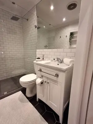 a white bathroom with a toilet and a sink at The Harfield Hideaway in Cape Town