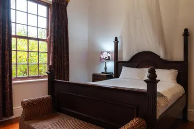 a bedroom with a large bed and a window at The Neighbours Farm - Homestead in Stellenbosch