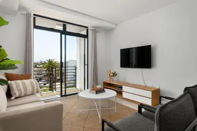 a living room with a couch and a tv at Beautiful Beach Break! in Cape Town