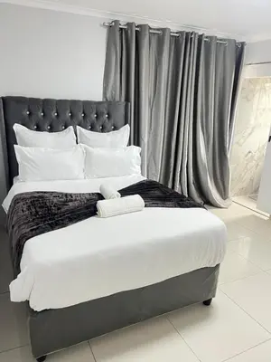 a bedroom with a large bed with a black headboard at The Perfect Place in Parow