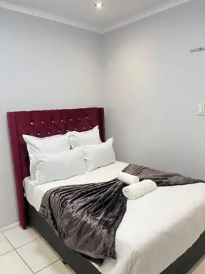 a bedroom with a large bed with a red headboard at The Perfect Place in Parow