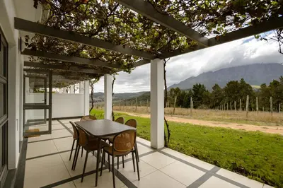 a patio with a table and chairs and a view at Jonker Estate - Serene stay on Helshoogte Pass in Stellenbosch