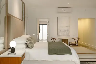 a bedroom with a large white bed and a table at Jonker Estate - Serene stay on Helshoogte Pass in Stellenbosch
