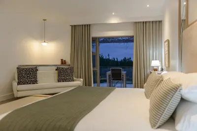 a hotel room with a large bed and a couch at Jonker Estate - Serene stay on Helshoogte Pass in Stellenbosch